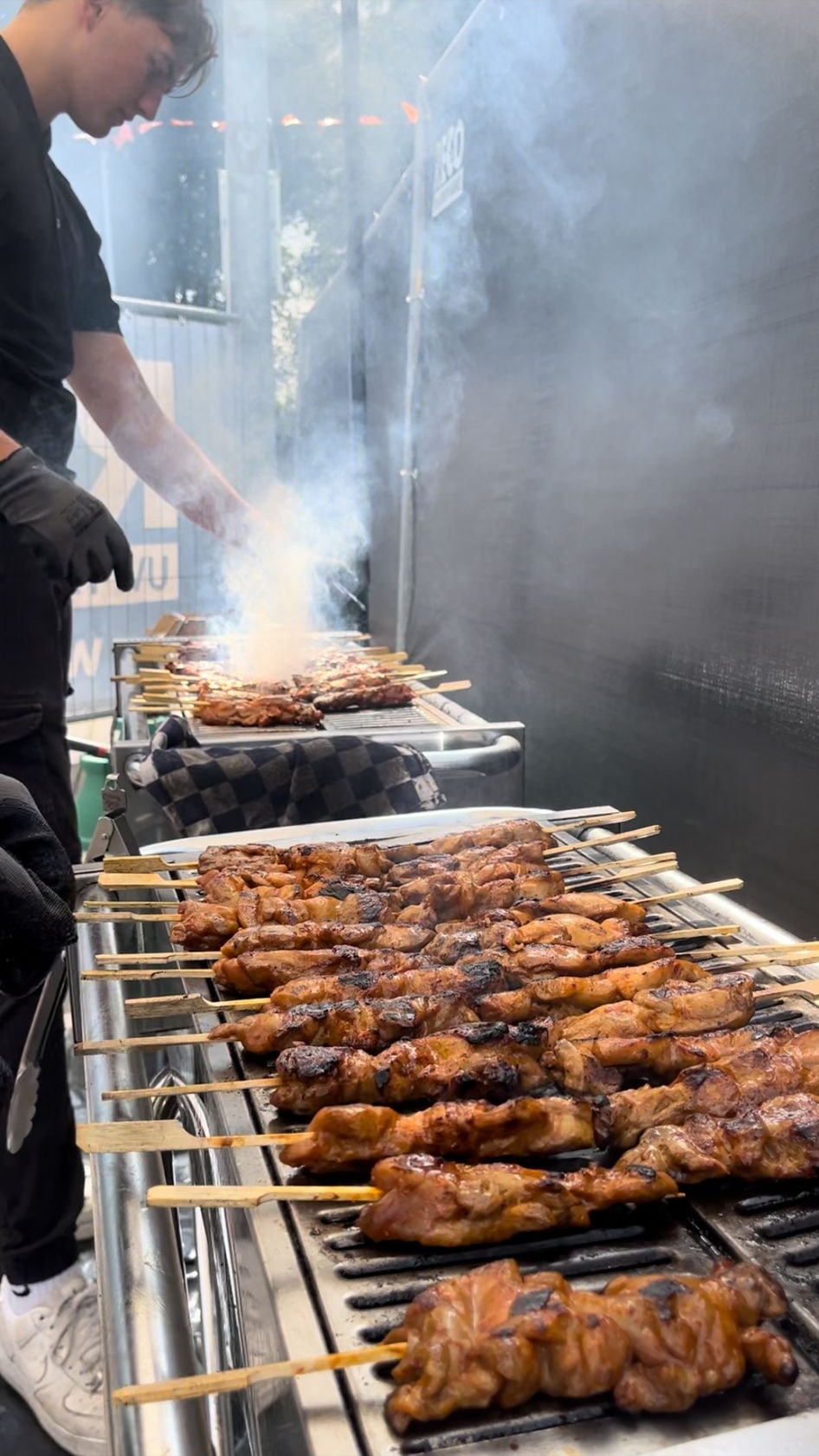 Kipsaté op de grill, met een medewerker van Vuur en Vlam aan het werk